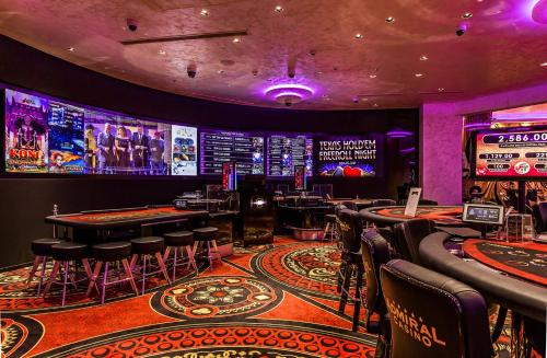 a casino with tables and stools in a room at Admiral Hotel in Zagreb