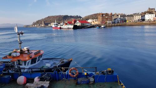 a boat is docked in a body of water at The Old Cottage in Arduaine