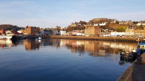 a river with buildings and boats in a city at The Old Cottage in Arduaine