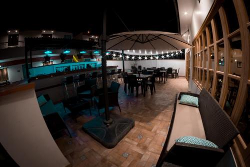 a restaurant with a table and chairs and an umbrella at Hotel Villa Jazmin in Ica
