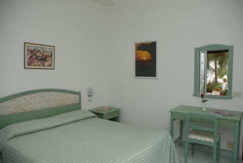 a bedroom with a bed and two tables and a mirror at La Citarea in Ischia