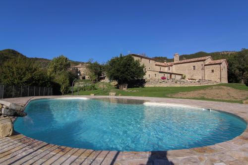 una gran piscina en un patio con una casa en Valbuona b&b, en Mercatello sul Metauro