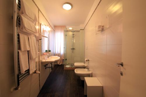 Un baño con dos inodoros, un lavabo y un espejo. en B&B Al Picchio, en Monopoli