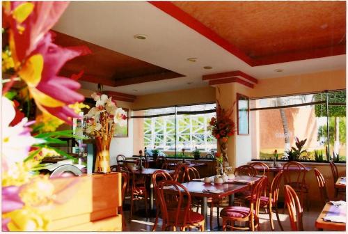 a dining room with tables and chairs and windows at Hotel del Parque in Ciudad del Carmen