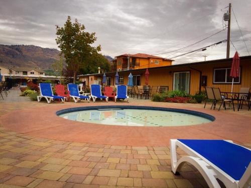 a small pool with chairs and a table and a building at Sahara Suites in Osoyoos