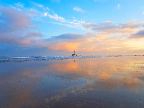 a boat in the water on the beach at sunset at Maison d'hôtes Cité Portugaise in El Jadida