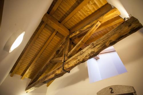 a ceiling with wooden beams and a window in a room at Agriturismo Cjargnei in Povoletto