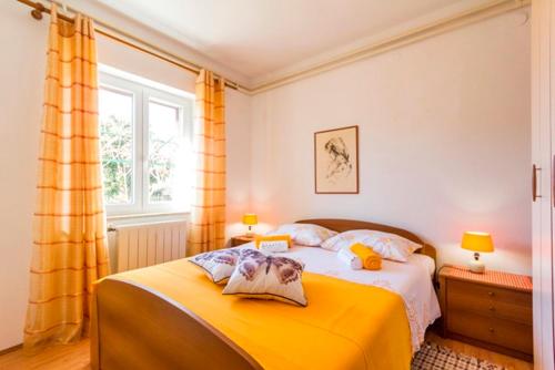 a bedroom with a yellow bed and a window at Apartment Lori in Fažana