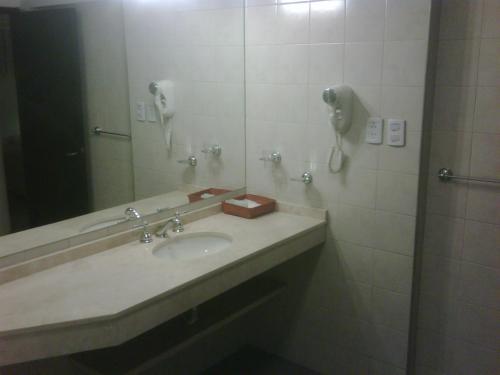 baño con lavabo, teléfono y espejo en Apartamentos Centricos en Mendoza