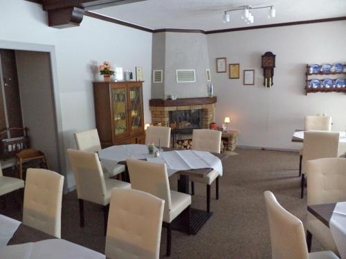 a dining room with a table and chairs and a fireplace at Landgasthof Fegetasch in Neukirchen
