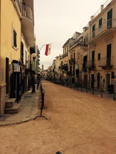 an empty street with buildings and a flag at Guest house Novecento in Palo del Colle