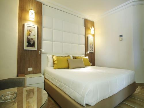 a bedroom with a large bed and a table at Sentido Bellevue Park in Port El Kantaoui