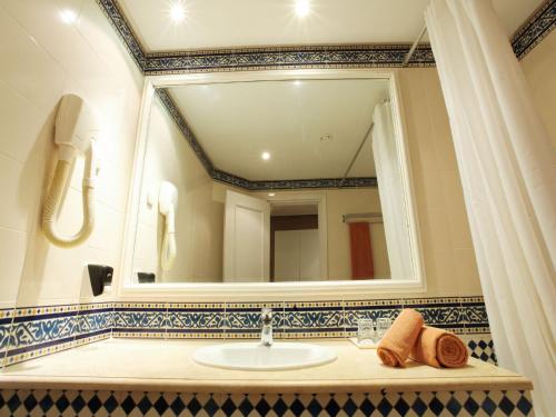 a bathroom with a sink and a large mirror at Sentido Bellevue Park in Port El Kantaoui