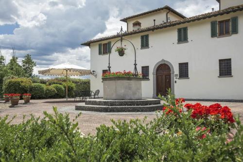 a white building with a flower planter in a courtyard at Viesca Toscana Suites & Villas in Reggello