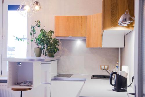 una cocina con encimeras blancas y armarios de madera en Apartament w centrum Gdyni, en Gdynia