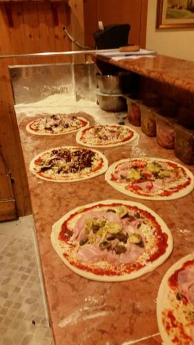 a group of pizzas sitting on a counter in a kitchen at Hotel Victory in Taio