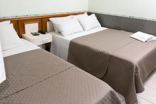 two beds sitting next to each other in a room at Hotel Residenza - 400m do inicio da Av Paulista e Metrô Paraiso in Sao Paulo