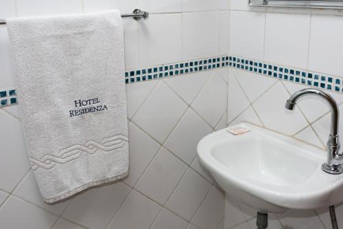 a bathroom with a white sink and a towel at Hotel Residenza - 400m do inicio da Av Paulista e Metrô Paraiso in Sao Paulo