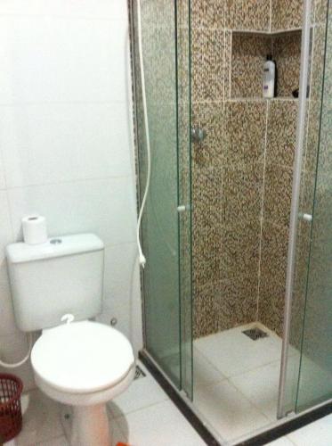 a bathroom with a toilet and a glass shower at Propriedade Silva in Gamboa