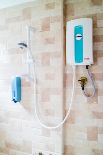 a shower in a bathroom with a soap dispenser at The Cube Sathorn Boutique Hotel เดอะ คิวบ์ สาทร บูติค โฮเทล Near BTS Surasak in Bangkok