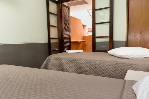 two beds sitting next to each other in a room at Hotel Residenza - 400m do inicio da Av Paulista e Metrô Paraiso in Sao Paulo