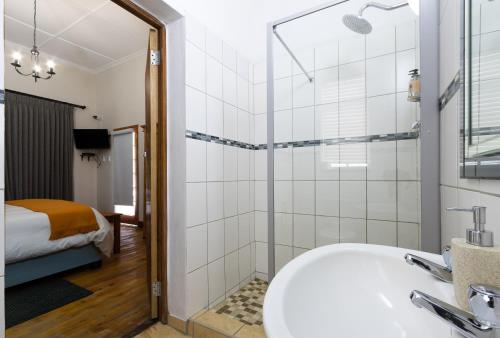 a bathroom with a tub and a shower and a bed at Horse and Mill Guesthouse in Colesberg