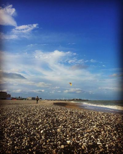 a person standing on a beach flying a kite at IL NIDO DELLA FORTUNA oasi di pace, relax, storia e mare in Fano