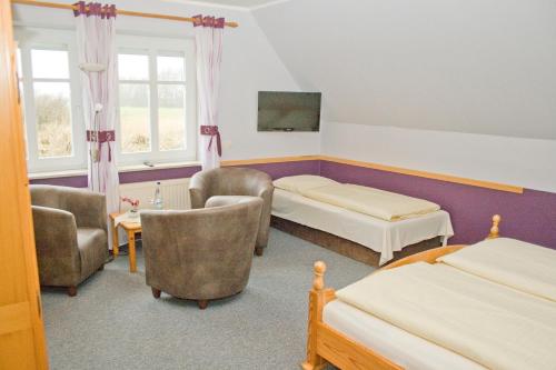a room with two beds and chairs and a tv at Landgasthof Fegetasch in Neukirchen