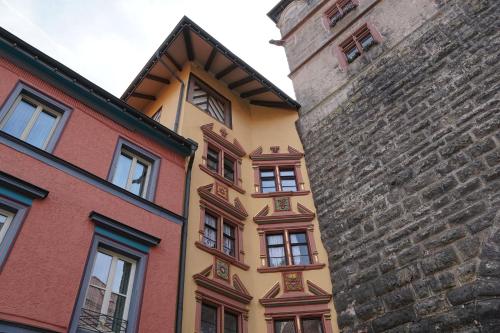 a yellow building next to a building next to a wall at MY HOME Hotel Lamm Rottweil "Smart Home" in Rottweil