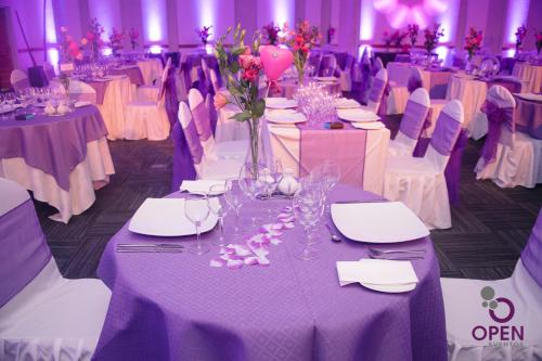 a room with tables with purple and white tablecloths at Open Hotel in Quillota
