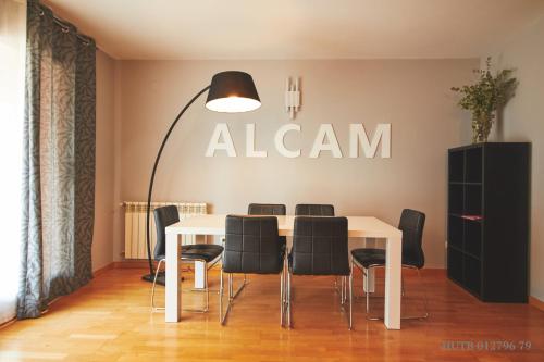 a dining room with a white table and black chairs at Alcam Badalona Playa Norte in Badalona