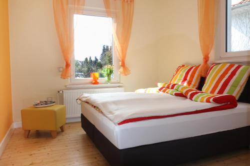 バート・ザルツフレンにあるTal-Residenz Erdgeschossのベッドルーム1室(オレンジ色のカーテンと窓付きのベッド1台付)