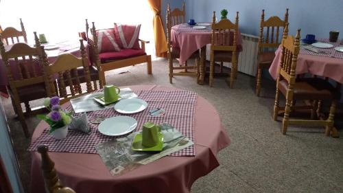 a dining room with two tables with pink table cloth at Hostal El Toque de Pilar in Punta Arenas