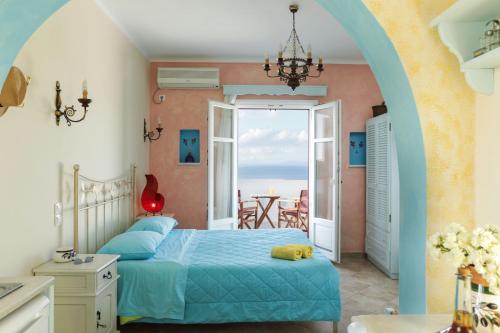 a bedroom with a bed and a view of the ocean at Villa Athina in Ambrami