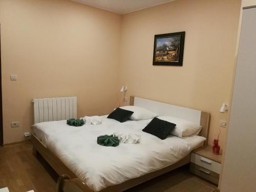 um quarto com uma cama branca com flores verdes em Apartman Fachin em Motovun