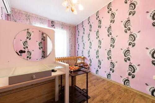 vestidor con paredes rosas y espejo en Guest House on Kaldaiakova 38, en Almaty
