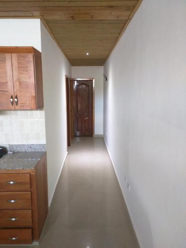 a hallway leading into a kitchen with a wooden door at Aparta Hotel Caribe Paraiso in Juan Dolio