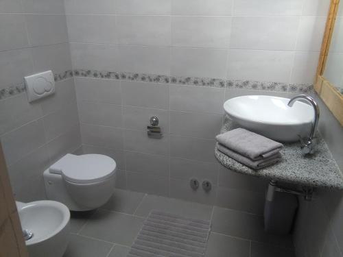 Baño blanco con lavabo y aseo en Appartamento Sole en Morgex