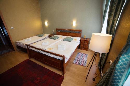 a bedroom with a large bed and a lamp at Hotel Bristol in Banská Štiavnica
