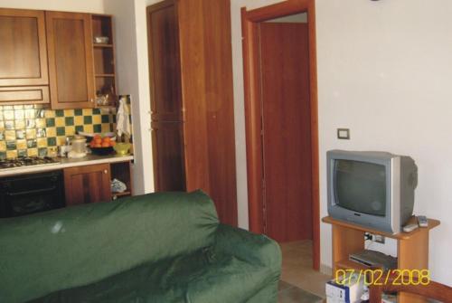 un soggiorno con divano verde e TV di Villetta Mirto a Siniscola