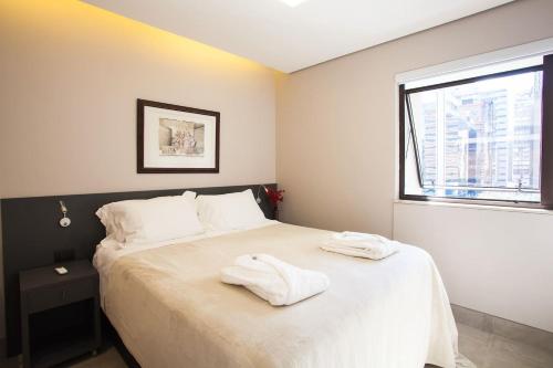 1 dormitorio con 1 cama con 2 toallas en BHomy Jardins Crème de la Crème LR902 en São Paulo