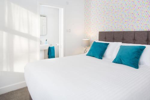a bedroom with a large white bed with blue pillows at Crown Apartment in Inverness