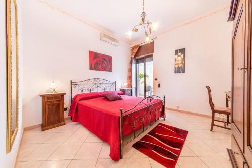 a bedroom with a red bed with a red blanket at Salento Sweet Home in Melissano