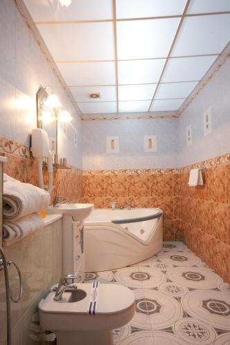 a bathroom with a tub and a sink and a toilet at Volter Hotel in Lviv