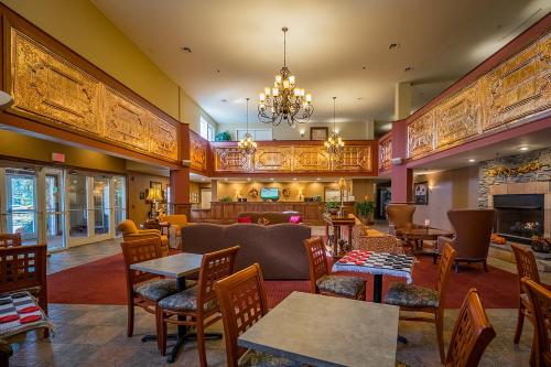 a restaurant with tables and chairs and a chandelier at Berkshire Mountain Lodge in Pittsfield