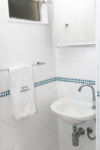 a white bathroom with a sink and a towel at Hotel Residenza - 400m do inicio da Av Paulista e Metrô Paraiso in Sao Paulo