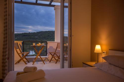 a bedroom with a bed and a view of a balcony at Villa Giove in Grohote