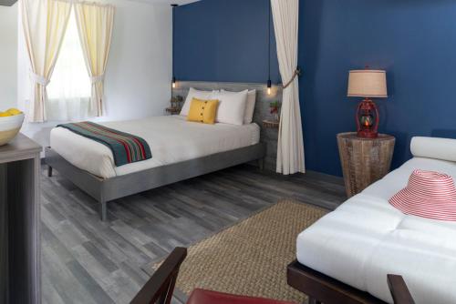 a bedroom with two beds and a blue wall at Treehouse Lodge in Woods Hole
