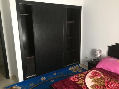 a bedroom with a large black cabinet next to a bed at Appartement De Luxe A Wilaya De Tetouan in Tetouan