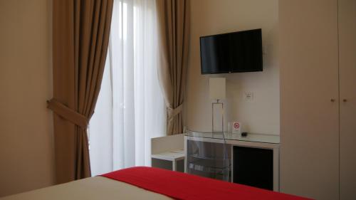 a hotel room with a bed and a television on the wall at Domus Nova in Reggio Calabria